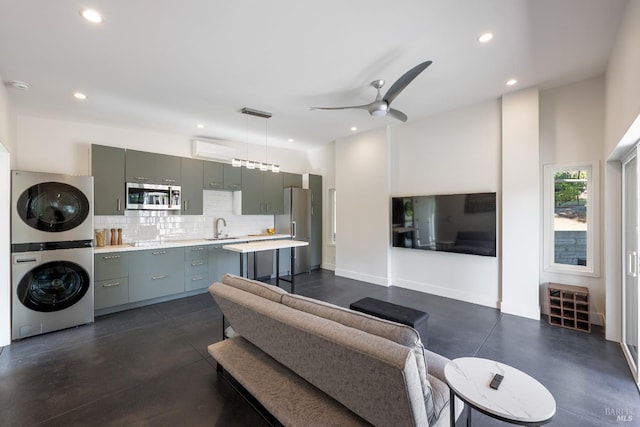 living room with ceiling fan, sink, and stacked washer and dryer