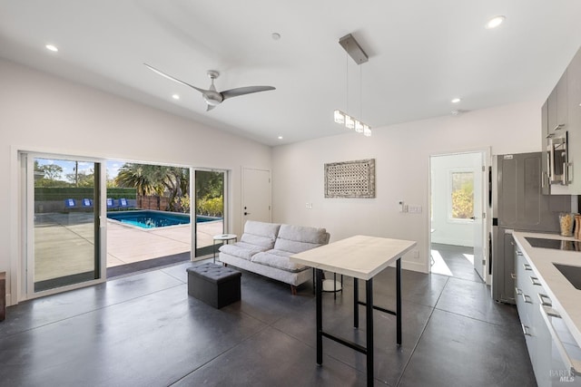 living room featuring ceiling fan, plenty of natural light, and lofted ceiling