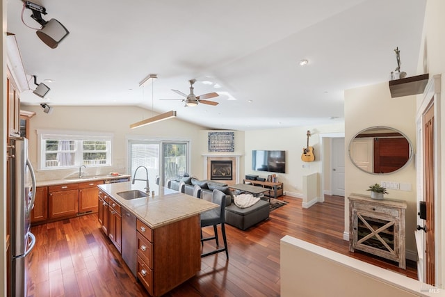 kitchen with a center island with sink, sink, vaulted ceiling, ceiling fan, and dark hardwood / wood-style flooring