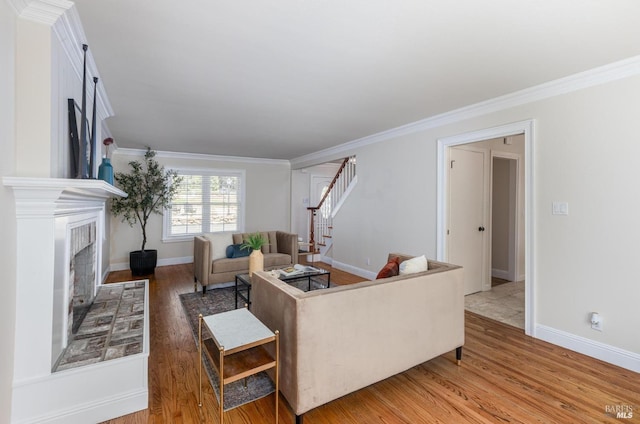 living room featuring a fireplace, hardwood / wood-style flooring, and ornamental molding