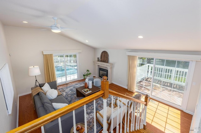 living room with ceiling fan, wood-type flooring, lofted ceiling, and a wealth of natural light