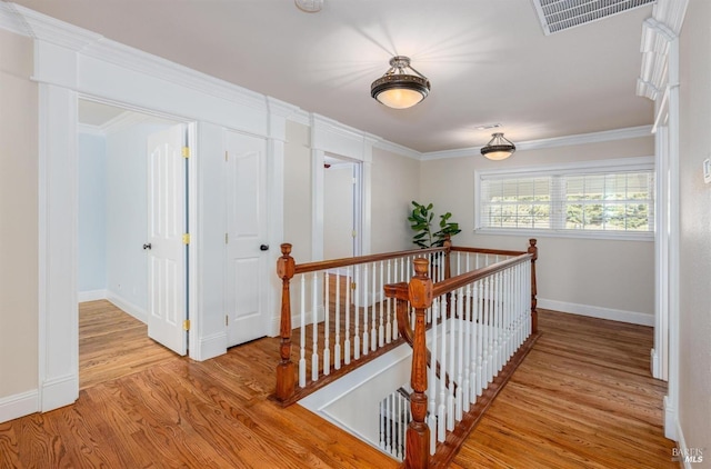 hall with light hardwood / wood-style flooring and ornamental molding