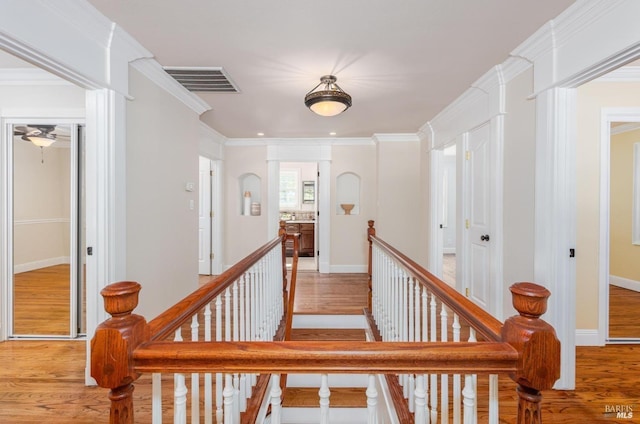 staircase with wood-type flooring, ceiling fan, and crown molding