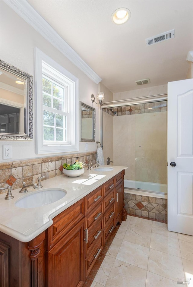 bathroom featuring tile patterned floors, tiled shower / bath combo, crown molding, and vanity