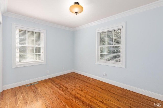 spare room with wood-type flooring and crown molding