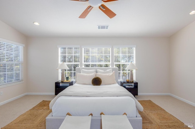 carpeted bedroom with multiple windows and ceiling fan