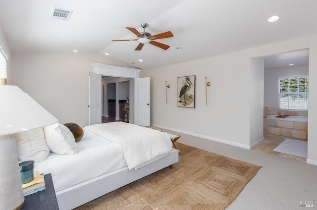 carpeted bedroom featuring ensuite bathroom, vaulted ceiling, and ceiling fan