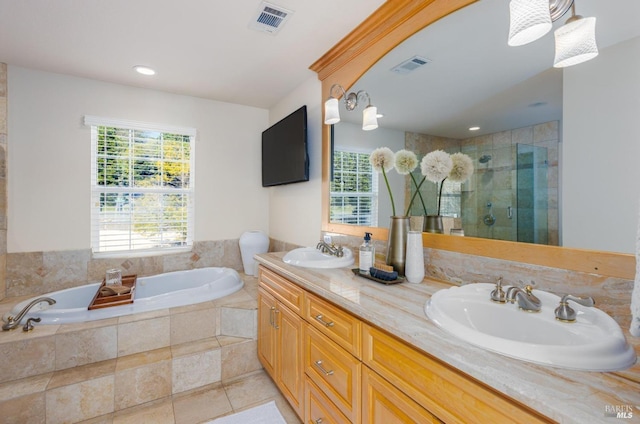 bathroom with tile patterned floors, vanity, and independent shower and bath