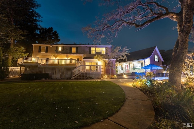 view of front of property featuring a deck and a yard