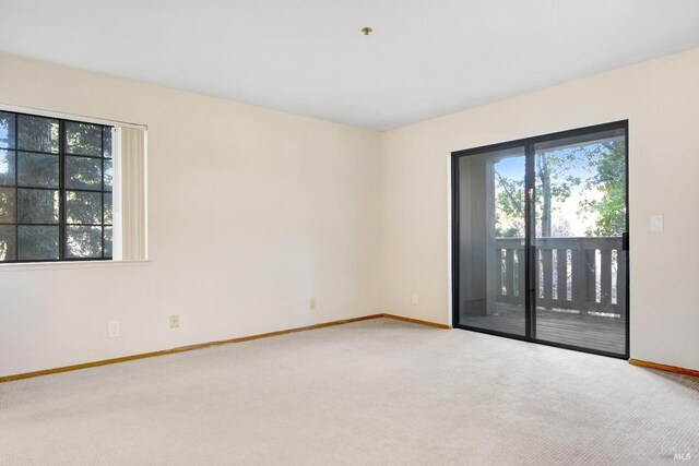 unfurnished bedroom featuring light colored carpet and ensuite bath