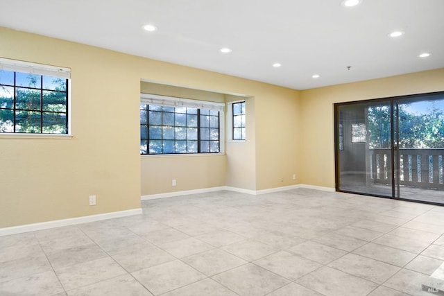 spare room featuring light tile patterned floors and a wealth of natural light