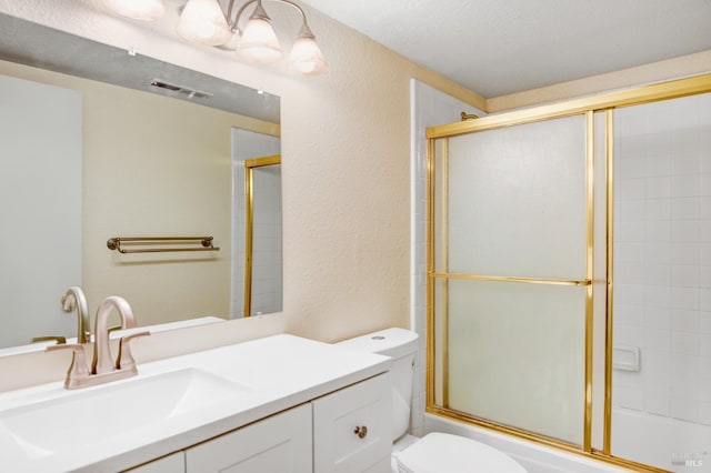 full bathroom with vanity, toilet, enclosed tub / shower combo, and a textured ceiling