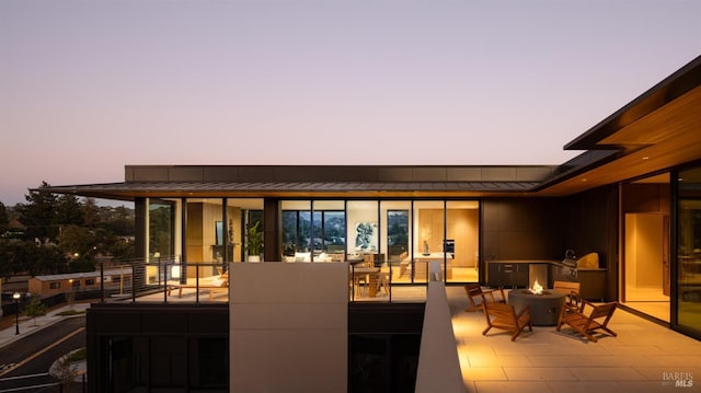 patio terrace at dusk featuring an outdoor fire pit