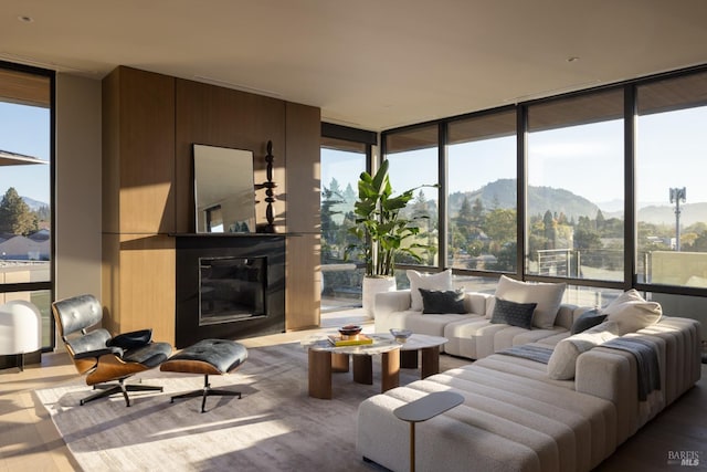 living room with a large fireplace, expansive windows, and wood-type flooring