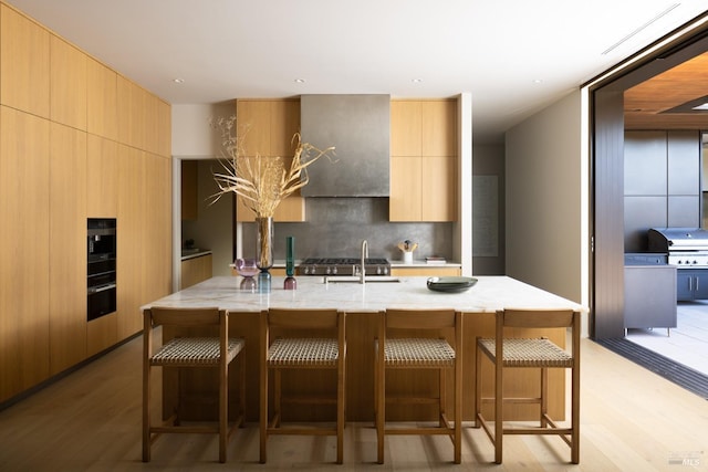 kitchen with a breakfast bar, modern cabinets, tasteful backsplash, and a sink