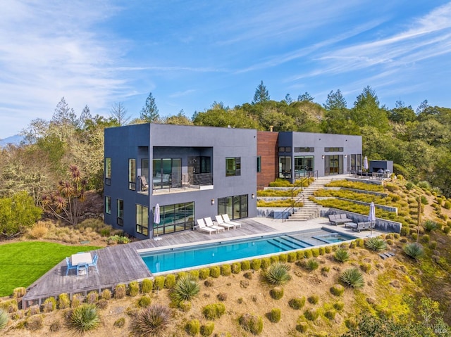 rear view of property with a balcony and a patio