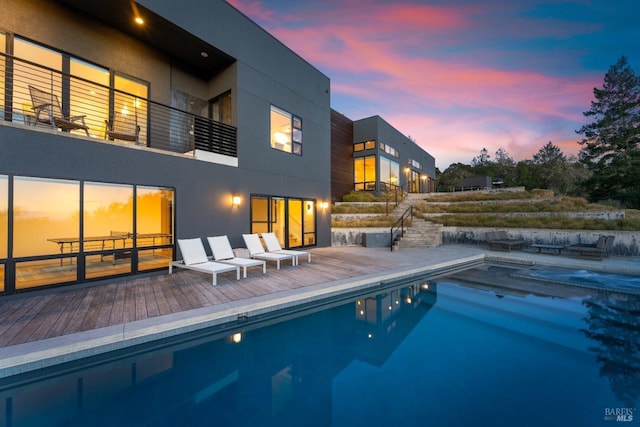 pool at dusk featuring a patio area