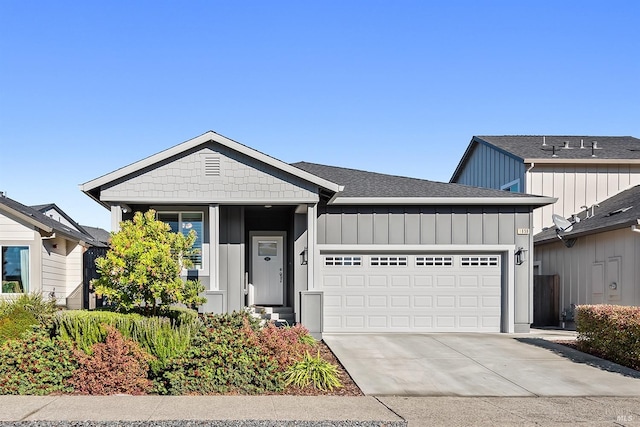 view of front of home featuring board and batten siding, concrete driveway, roof with shingles, and an attached garage