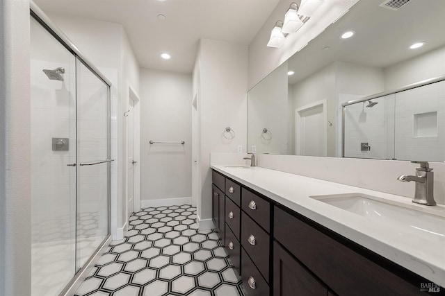 bathroom featuring double vanity, a shower stall, and a sink