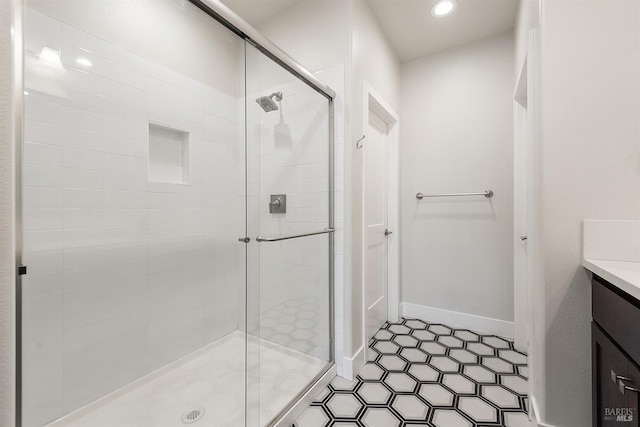 bathroom with baseboards, a stall shower, vanity, and recessed lighting