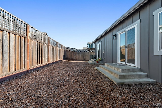 view of yard with entry steps and a fenced backyard