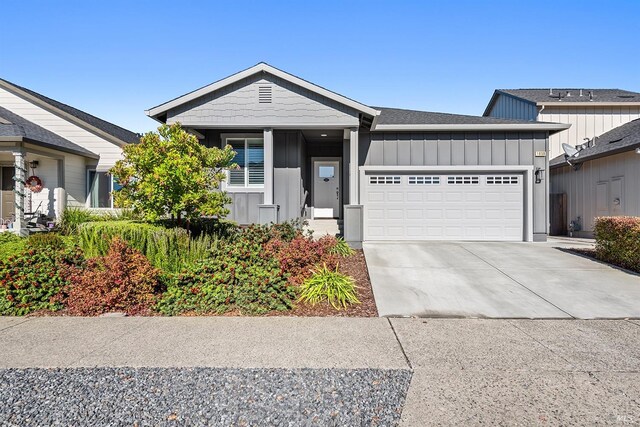 ranch-style house with an attached garage, board and batten siding, and concrete driveway