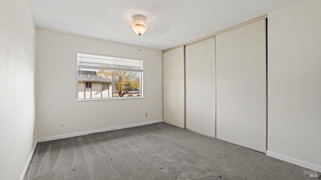 unfurnished bedroom featuring carpet flooring, ceiling fan, and a closet