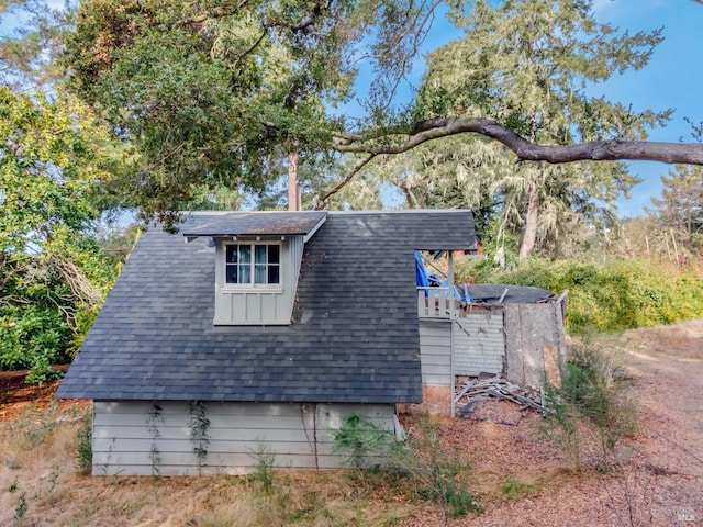 view of side of property with roof with shingles