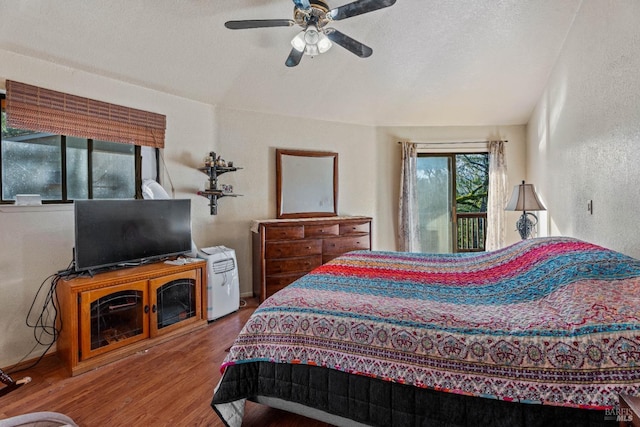 bedroom with access to exterior, wood-type flooring, a textured ceiling, and ceiling fan