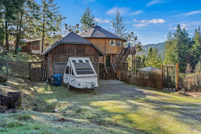 view of front of property with a garage, an outbuilding, and a front lawn