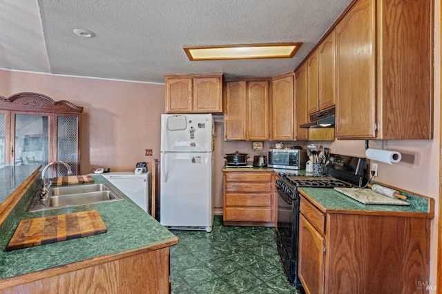 kitchen with a textured ceiling, white refrigerator, black range with gas stovetop, and sink