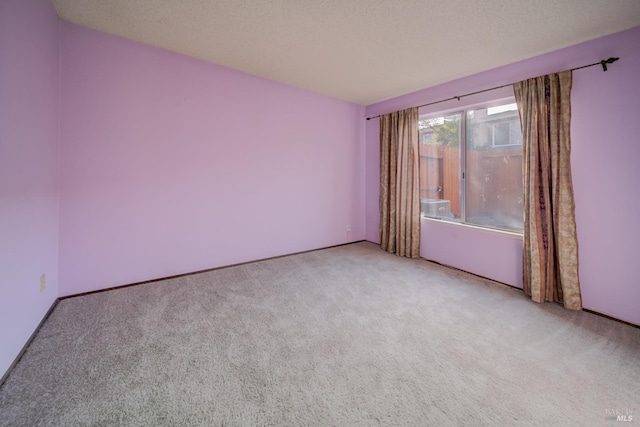 carpeted empty room with a textured ceiling