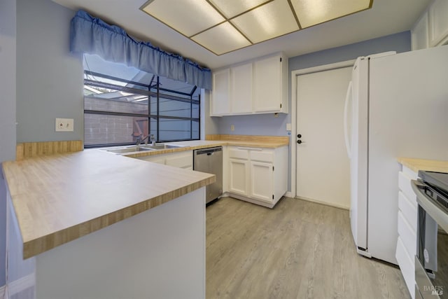 kitchen featuring kitchen peninsula, sink, appliances with stainless steel finishes, light hardwood / wood-style floors, and white cabinetry