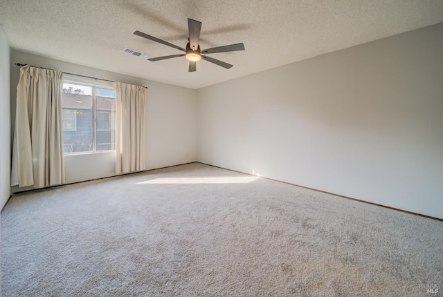 unfurnished room with ceiling fan, light colored carpet, and a textured ceiling