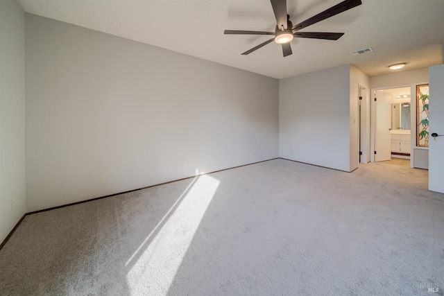 unfurnished room with ceiling fan and light carpet