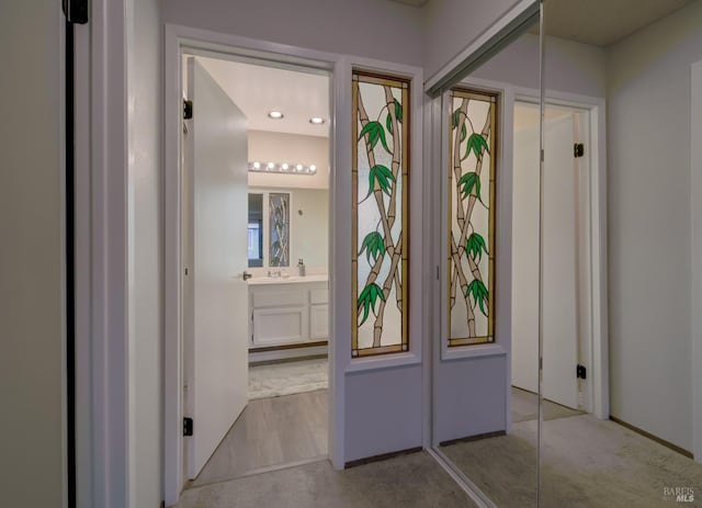 hallway featuring light colored carpet