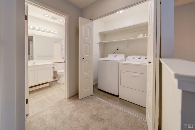 clothes washing area featuring washer and dryer and light colored carpet