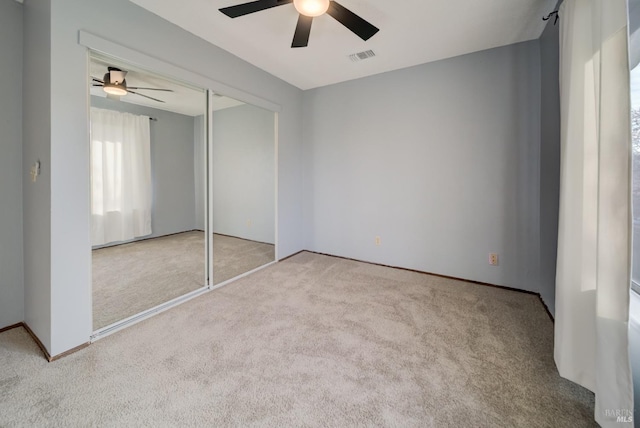 unfurnished bedroom with ceiling fan, a closet, and light carpet