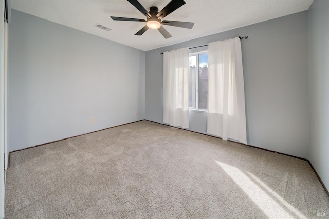 carpeted spare room with ceiling fan