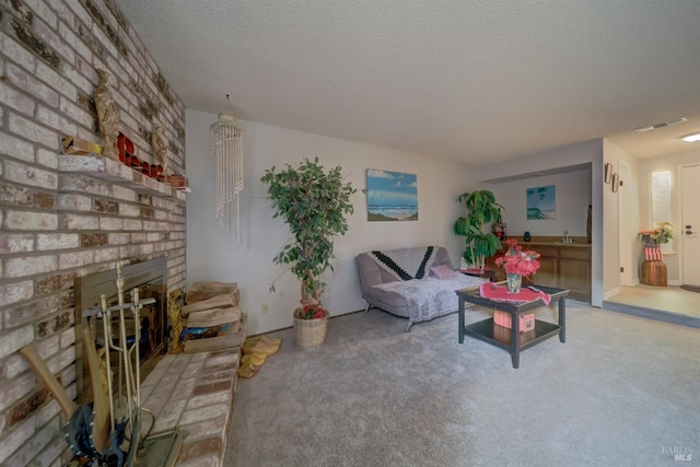 living room with sink, light colored carpet, a textured ceiling, and a brick fireplace