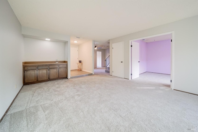 carpeted spare room featuring ceiling fan and sink