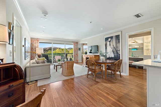 dining area with light hardwood / wood-style floors and crown molding