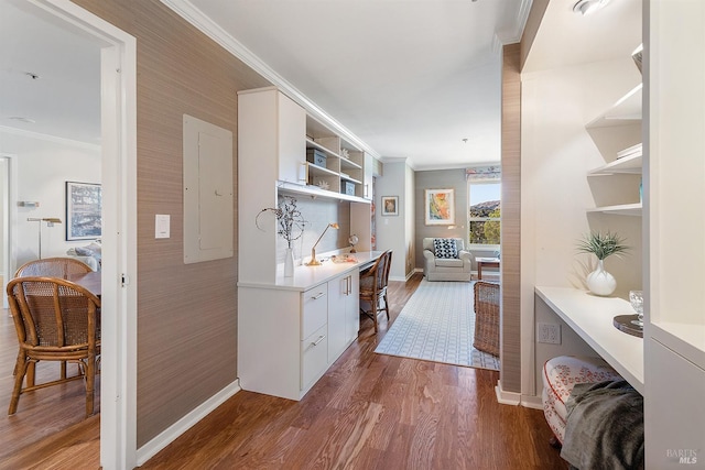 interior space featuring hardwood / wood-style floors, electric panel, white cabinets, built in features, and ornamental molding