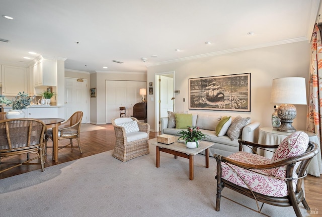 living room featuring ornamental molding and light wood-type flooring