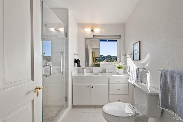 bathroom featuring tile patterned flooring, vanity, a shower with door, and toilet