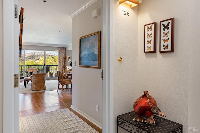 hall with hardwood / wood-style flooring and ornamental molding