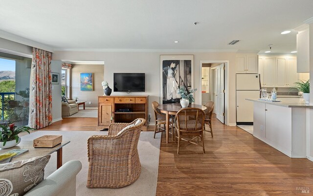 living room with crown molding and light hardwood / wood-style floors