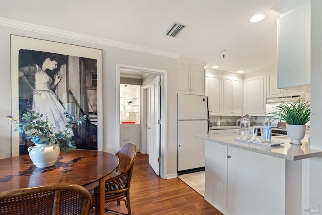 kitchen featuring light wood-type flooring, white fridge, white cabinetry, and crown molding