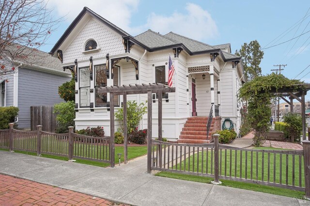 victorian house featuring a front lawn and covered porch