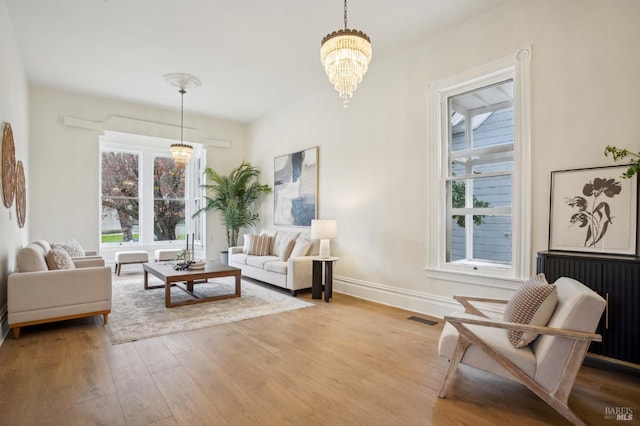 living room with an inviting chandelier and light wood-type flooring